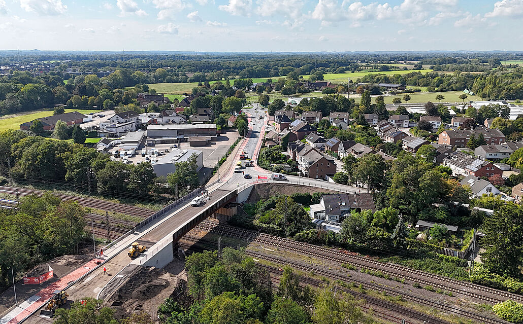 Luftaufnahme der Cölve-Brücke über mehrere Bahngleise, umgeben von Wohnhäusern und viel Grün.