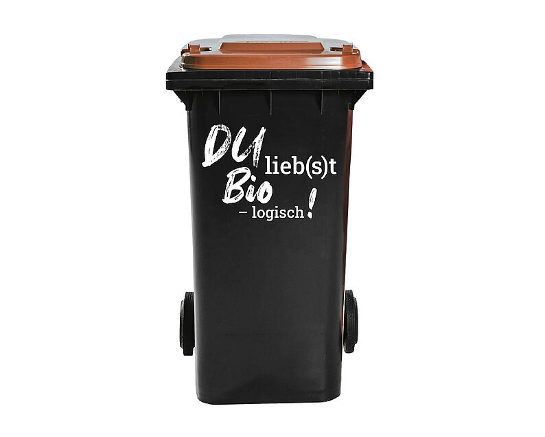 Schwarze Biotonne mit braunem Deckel mit Aufschrift 'Du lieb(s)t Bio – logisch!' 